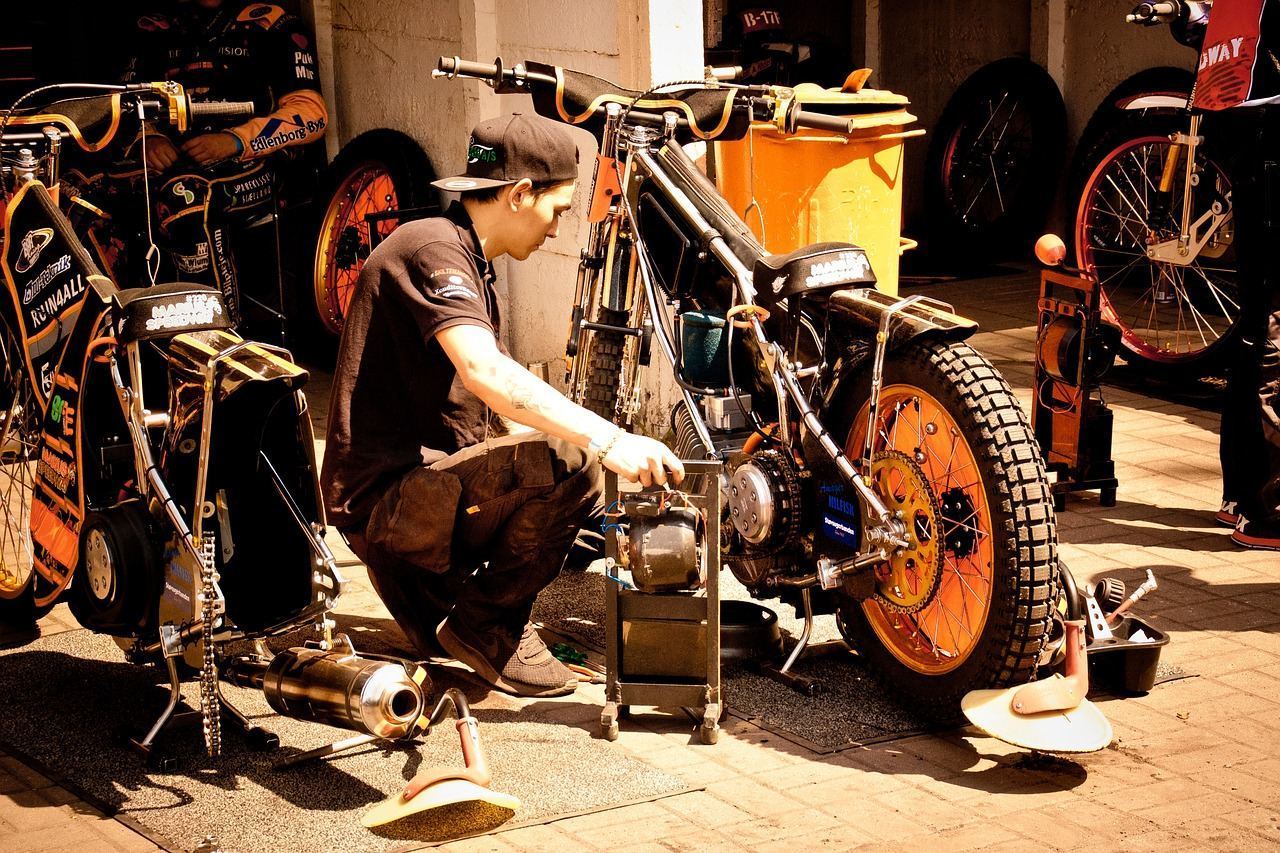 Mechanik przygotowuje motocykl żużlowy przed 18. kolejką PGE Ekstraligi.